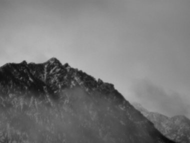 Sis ve bulutlarla kaplı dağ manzarası