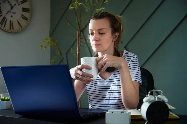 Woman at home office workplace using laptop. Female freelancer working at living room