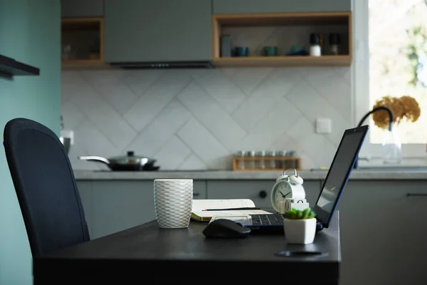 stock image Workplace with table and laptop at the kitchen. Home office and remote work concept