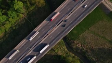 Orman ağaçlarının yanındaki otoyolda giden arabalar, manzarası çok güzel. Kırsal kesimde araba trafiği olan asfalt yolda hava aracı görüntüsü