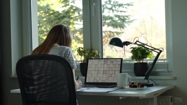 ラップトップ付きのホームオフィスの職場 自宅からノートパソコンで遠隔作業をする女性 窓の近くのテーブルに座っている女性のフリーランサー — ストック動画