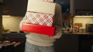 Kadınlar Noel arifesinde arkadaşları ve akrabaları için hediyeler hazırlar. Kadın hediye kutuları içinde el işi kağıtlara sarılmış hediyeler tutuyor.