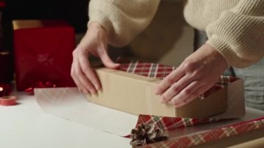 Sıcak kazaklı bir kadın, hediye paketi ve el işi kâğıdı. Kış tatili hediyesi. Noel ve Mutlu Yıllar Kutlaması