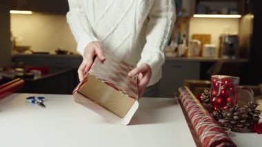 Sıcak kazaklı bir kadın, hediye paketi ve el işi kâğıdı. Kış tatili hediyesi. Noel ve Mutlu Yıllar Kutlaması