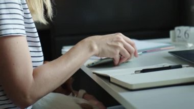 Evden çalışan serbest çalışan biri. Yaratıcı tasarımcı deftere çizim yapıyor. Pencerenin yanındaki masada dizüstü bilgisayarı olan uzak çalışma yeri