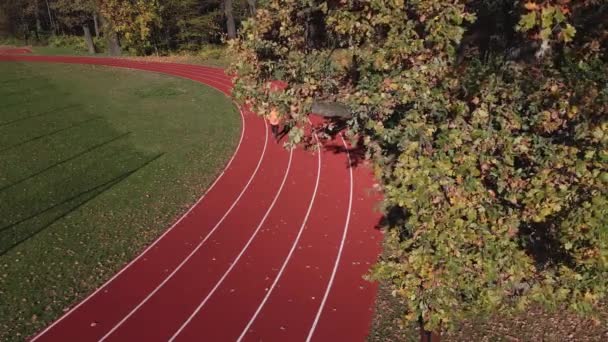 Człowiek Pomarańczowym Stroju Sportowym Biegający Torze Wyścigowym Widok Lotu Drona — Wideo stockowe
