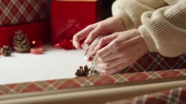Sıcak kazaklı bir kadın, hediye paketi ve el işi kâğıdı. Kış tatili hediyesi. Noel ve Mutlu Yıllar Kutlaması