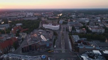 Drone flight over Hilton hotel building in Wroclaw city, Poland. Aerial view of morning cityscape with view on Odra river at sunrise. Wrocalw, Poland - July 29, 2022