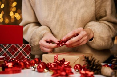 Sıcak kazaklı bir kadın, hediye paketi ve el işi kâğıdı. Kış tatili hediyesi. Noel ve Mutlu Yıllar Kutlaması