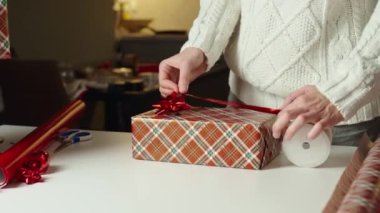 Sıcak kazaklı bir kadın, hediye paketi ve el işi kâğıdı. Kış tatili hediyesi. Noel ve Mutlu Yıllar Kutlaması