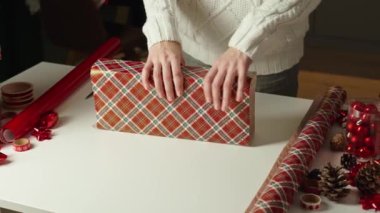 Sıcak kazaklı bir kadın, hediye paketi ve el işi kâğıdı. Kış tatili hediyesi. Noel ve Mutlu Yıllar Kutlaması