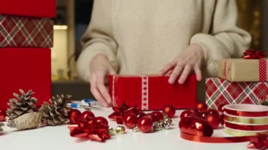 Sıcak kazaklı bir kadın, hediye paketi ve el işi kâğıdı. Kış tatili hediyesi. Noel ve Mutlu Yıllar Kutlaması