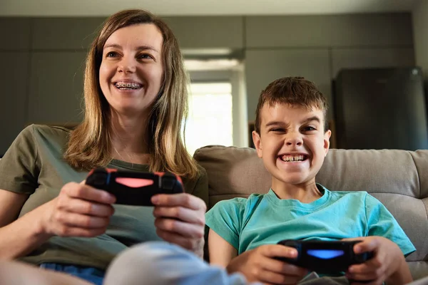 Son and mother playing video game at home, Family spending time together, Happy relationship, Online entertainment and leisure activity