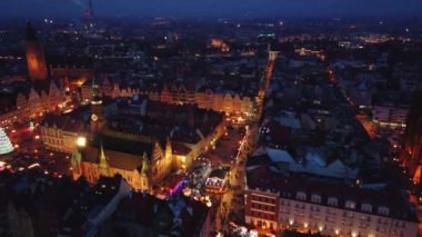 Wroclaw eski kasaba meydanında Noel süsü ve aydınlatma ile insansız hava aracı uçuşu. Wroclaw 'daki Noel fuarında yürüyen turistler. Wroclaw, Polonya - 09 Aralık 2022
