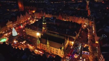 Wroclaw eski kasaba meydanında Noel süsü ve aydınlatma ile insansız hava aracı uçuşu. Wroclaw 'daki Noel fuarında yürüyen turistler. Wroclaw, Polonya - 09 Aralık 2022
