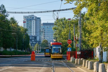 Sarı tramvay Varşova sokaklarındaki istasyondan ayrılıyor. Toplu taşıma. Varşova, Polonya - 4 Eylül 2022