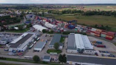 Terminaldeki MAERSK konteynırlarının yüklenmesi, demiryolu platformundaki vinçleri ve forkliftleri olan konteynırların boşaltılması, hava manzarası. Katy Wroclawskie, Polonya - 29 Eylül 2022