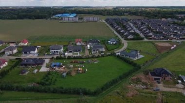 Polonya 'nın banliyö yerleşim bölgesi üzerinde İHA uçuşu. Mahalledeki aile evleri, hava manzaralı.