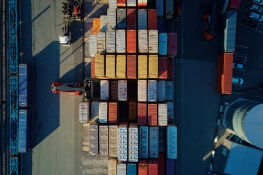 Terminaldeki nakliye konteynerleri, demiryolu platformundaki konteynırları vinçlerle ve forkliftlerle boşaltmak, hava manzaralı...