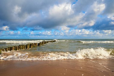 Yaz günü dalgalı deniz kıyısı. Güzel bulutlu gökyüzüne karşı Baltık sahili. Panoramik doğa manzarası