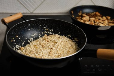 Process of cooking risotto. Arborio rice in frying pan at home kitchen. Italian cuisine dish