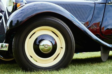 Classic car details. Wheel of black retro car. Katy Wroclawskie, Poland - May 28, 2022