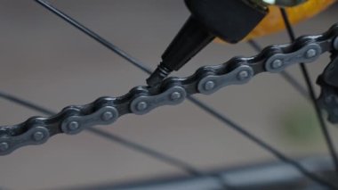 Bike chain is lubricated with oil, close up. Bicycle transmission maintenance