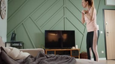 Woman doing sport exercises at home, watching online tutorial on laptop. Sport training and fitness concept. Healthy lifestyle for wellness