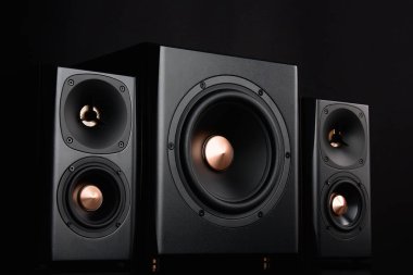 Two sound speakers and subwoofer on dark background. Set for listening music. Audio equipment