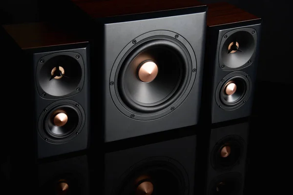 Two sound speakers and subwoofer on dark background. Set for listening music. Audio equipment