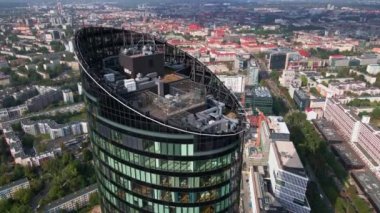 Drone flight over skyscraper. Modern office building, aerial view. Cityscape panorama with business center glass facade in Wroclaw, Poland