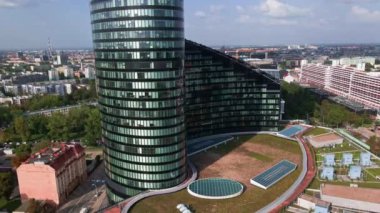 Flight over skyscraper against cityscape. High rise building facade with windows, aerial view. Sky Tower building in Wroclaw, Poland