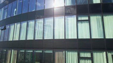 Skyscraper glass facade, aerial view. Modern office building exterior with large windows. Detail of high rise building