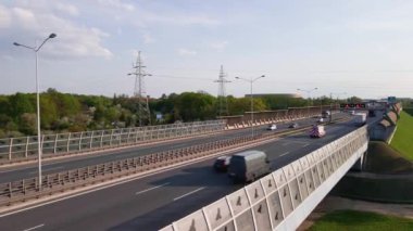 Car traffic on bridge against city landscape, aerial view. Rush hour on road highway.