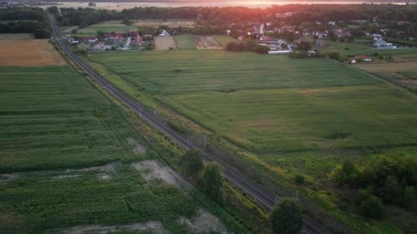 日落时铁路在农村地区的空中景观 农业用地附近的铁路 — 图库视频影像