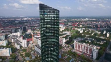 Flight over skyscraper against cityscape. High rise building facade with windows, aerial view. Sky Tower building in Wroclaw, Poland