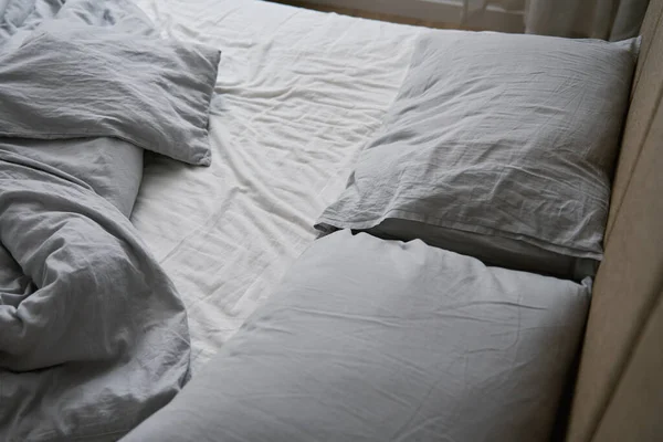 寝た後に作られなかったベッド ベッドルームで枕 毛布としわのあるシートでベッド 朝の家事 — ストック写真