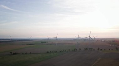 Yel değirmeni türbin jeneratörünün temiz, yenilenebilir, sürdürülebilir alternatif enerji kavramı kırsal alanda güzel günbatımı gökyüzüne karşı havadan görüntüsü