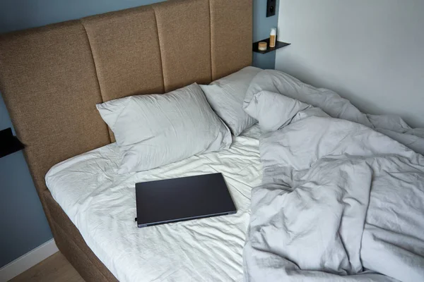 아침에는 베개와 구겨진 침대보로 만들지 침대에 랩탑을 열었다 프리랜서를 집에서 — 스톡 사진