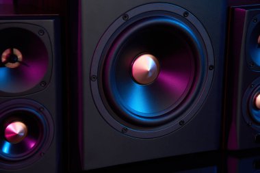 Neon ışıklı multimedya ses hoparlörleri. İki uydulu ses sistemi ve koyu arkaplanda subwoofer..