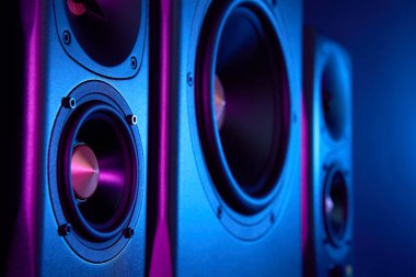 Neon ışıklı multimedya ses hoparlörleri. İki uydulu ses sistemi ve koyu arkaplanda subwoofer..