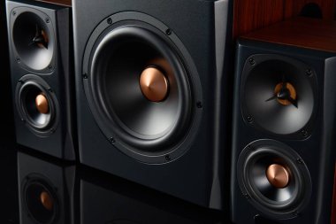 Multimedya ses hoparlörleri. İki uydusu olan ses sistemi ve koyu arkaplanda subwoofer. Müzik dinlemek için müzik sistemi