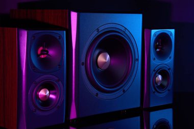 Neon ışıklı multimedya ses hoparlörleri. İki uydulu ses sistemi ve koyu arkaplanda subwoofer..