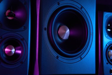 Neon ışıklı multimedya ses hoparlörleri. İki uydulu ses sistemi ve koyu arkaplanda subwoofer..