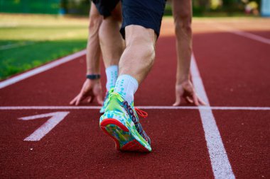 Stadyum pistinde Asıcs Noosa Tri 13 giyen koşucu koşmaya hazırlanıyor. Stadyumda spor ve spor atleti antrenmanı. Katy Wroclawskie, Polonya - 10 Haziran 2023