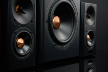 Multimedya ses hoparlörleri. İki uydusu olan ses sistemi ve koyu arkaplanda subwoofer. Müzik dinlemek için müzik sistemi