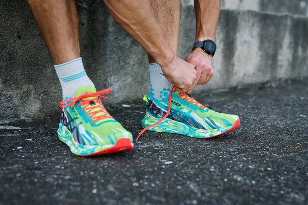 stock image Athletic man tying his running shoes before exercising. Male runner wearing Asics Noosa Tri 13 at stadium track preparing to running. Katy Wroclawskie, Poland - June 10, 2023