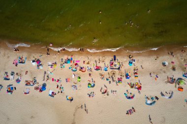 Wladyslawo 'daki kalabalık kumsal manzaralı deniz manzarası. Polonya 'da yüzen insanlarla dolu Baltık deniz kıyıları. Yaz mevsiminde tatil köyü