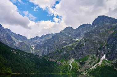 Yaz günü güzel göl kenarındaki dağların muhteşem manzarası. Polonya 'daki Tatra Ulusal Parkı. Beş Göl Vadisi 'ndeki Morskie Oko ya da Sea Eye Gölü' nün panoramik manzarası