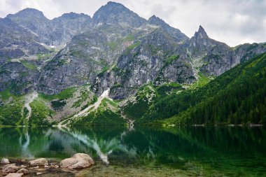 Yaz günü güzel göl kenarındaki dağların muhteşem manzarası. Polonya 'daki Tatra Ulusal Parkı. Beş Göl Vadisi 'ndeki Morskie Oko ya da Sea Eye Gölü' nün panoramik manzarası